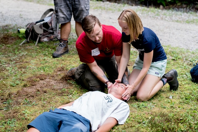 Intervenants pratiquant les premiers secours sur une victime lors d’une formation TECC en extérieur.
